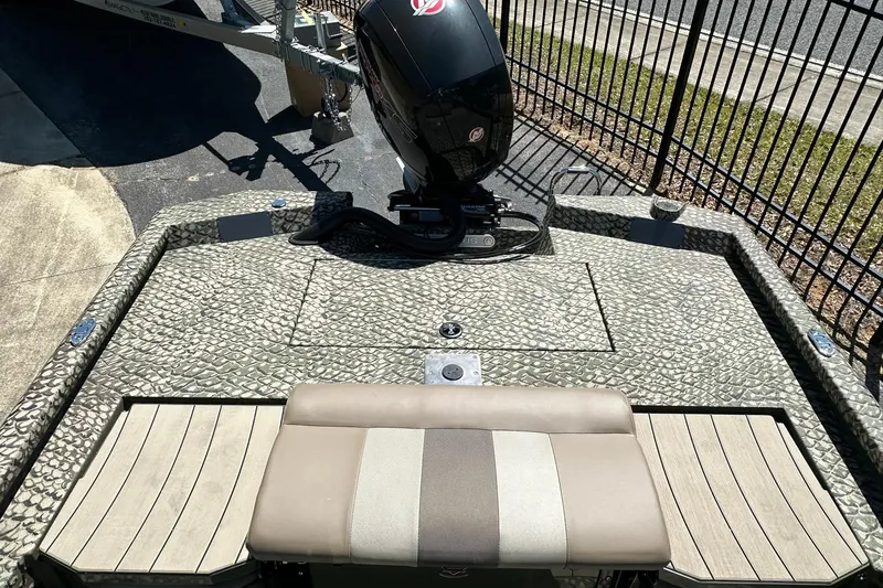 Slide: The Image of 2026 Vexus ACX 2000 boat with textured deck and outboard motor, parked near a fence. - 11