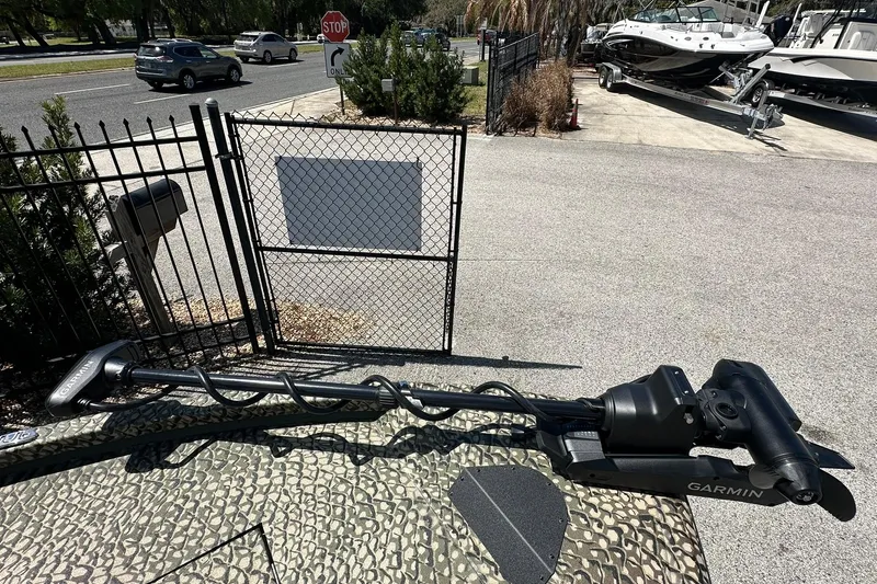 Slide: The Image of 2026 Vexus ACX 2000 boat with Garmin trolling motor, parked near a gated area. - 24