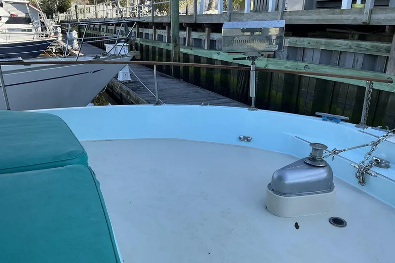 Slide: The Image of 1972 Whitcraft Hatteras boat deck with seating and anchor equipment at a marina. - 10
