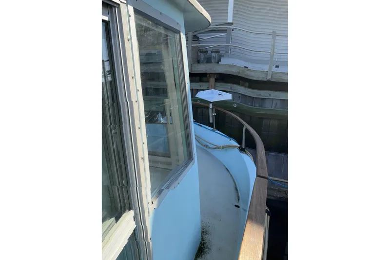 Slide: The Image of 1972 Whitcraft Hatteras boat docked, showcasing side view and windows. - 11