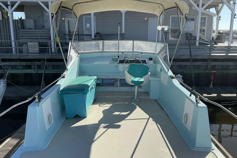 Slide: The Image of 1972 Whitcraft Hatteras boat interior with seating and steering, docked at a marina. - 17