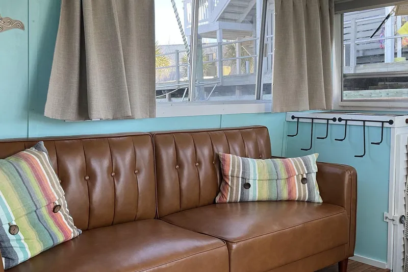 Slide: The Image of Vintage 1972 Whitcraft Hatteras interior with brown leather sofa and colorful striped pillows. - 24