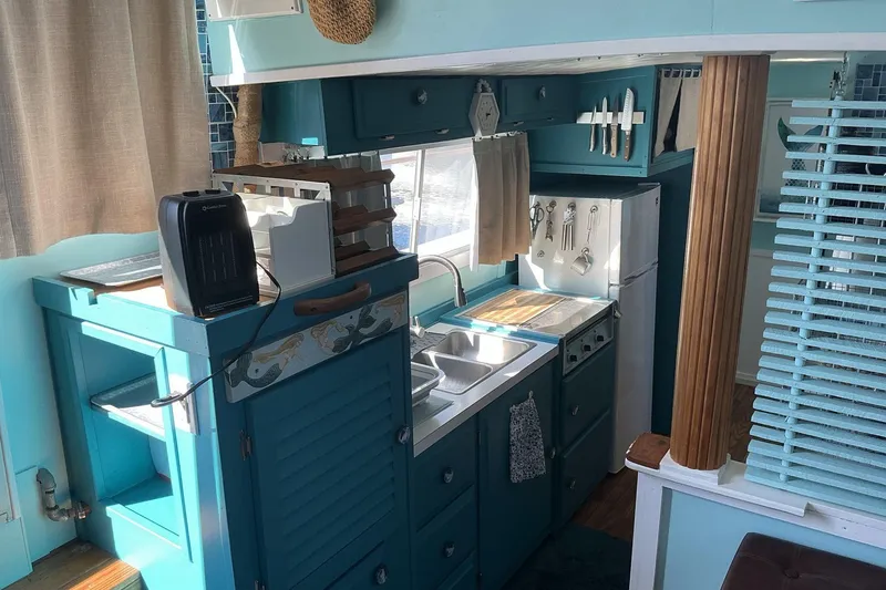 Slide: The Image of 1972 Whitcraft Hatteras boat kitchen with teal cabinets, sink, and appliances. - 26