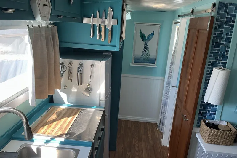 Slide: The Image of Interior of a 1972 Whitcraft Hatteras boat with teal kitchen and nautical decor. - 27