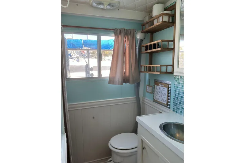Slide: The Image of Small bathroom in a 1972 Whitcraft Hatteras boat with sink, toilet, and window. - 29