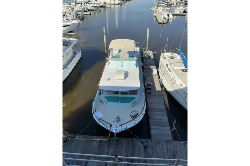 Slide: The Image of 1972 Whitcraft Hatteras boat docked at marina, surrounded by other vessels. - 3