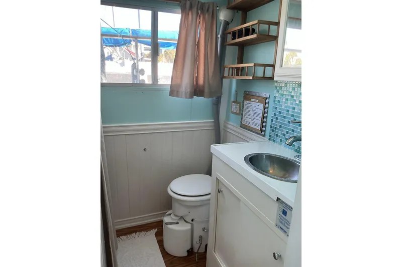 Slide: The Image of 1972 Whitcraft Hatteras boat bathroom with sink, toilet, and nautical decor. - 30