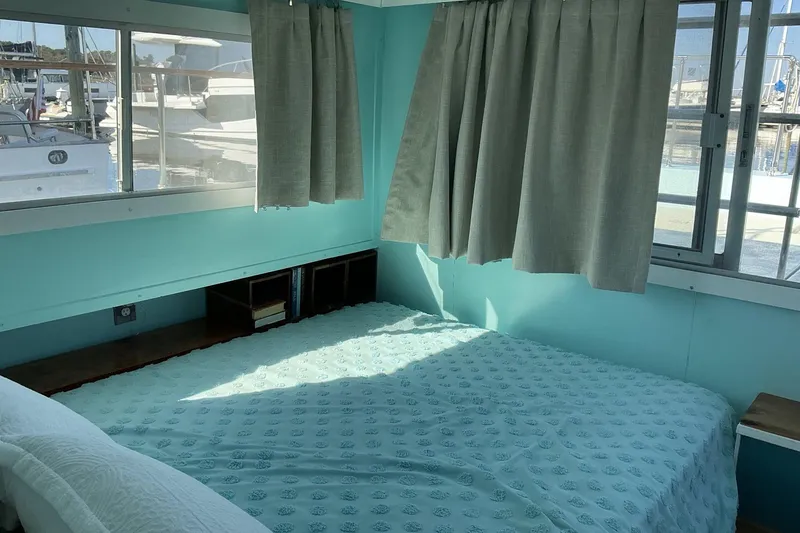 Slide: The Image of Cozy bedroom interior on a 1972 Whitcraft Hatteras boat with teal decor and large windows. - 31