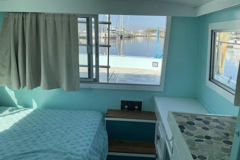 Slide: The Image of Interior of a 1972 Whitcraft Hatteras boat with light blue walls and marina view. - 32