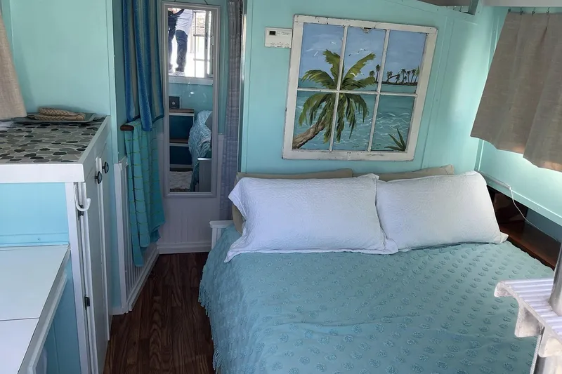 Slide: The Image of Cozy bedroom in a 1972 Whitcraft Hatteras boat with tropical decor and light blue accents. - 34