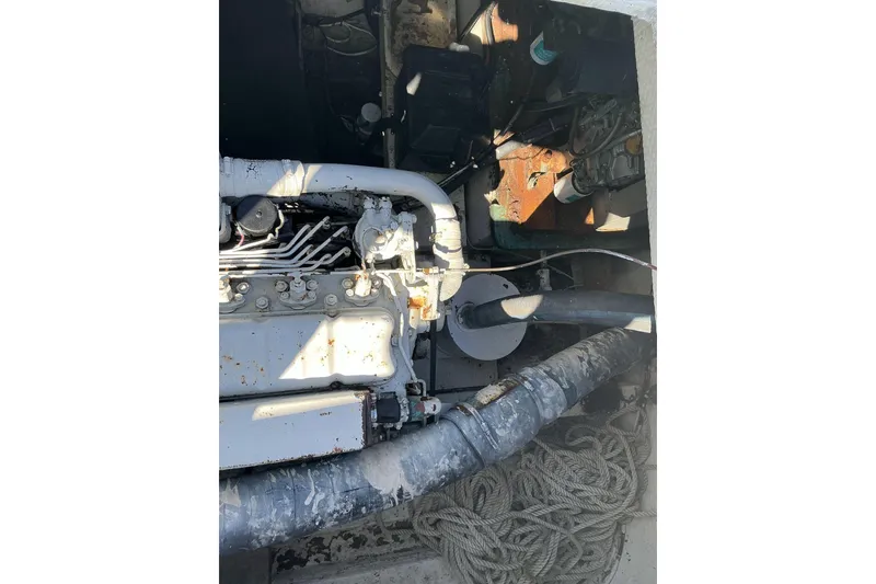 Slide: The Image of Engine compartment of a 1972 Whitcraft Hatteras boat, showing mechanical components and ropes. - 36