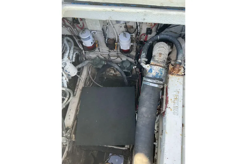 Slide: The Image of Engine compartment of a 1972 Whitcraft Hatteras boat, showing hoses and mechanical components. - 38