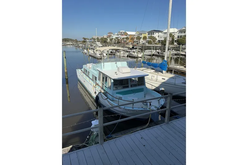 Slide: The Image of 1972 Whitcraft Hatteras boat docked at a marina, surrounded by other vessels. - 4
