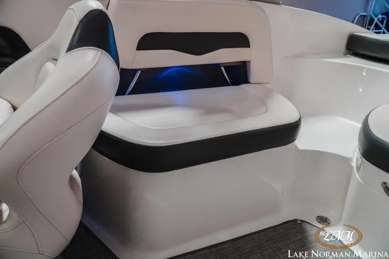 Slide: The Image of 2017 Chaparral 246 SSi boat interior with white and black seating, blue accent lighting. - 16