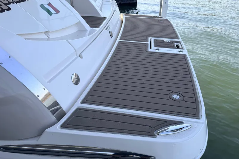 Slide: The Image of 2005 Regal 3350 Sport Cruiser swim platform with teak decking by the water. - 13