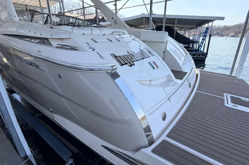 Slide: The Image of 2005 Regal 3350 Sport Cruiser docked, showcasing sleek design and spacious deck. - 14