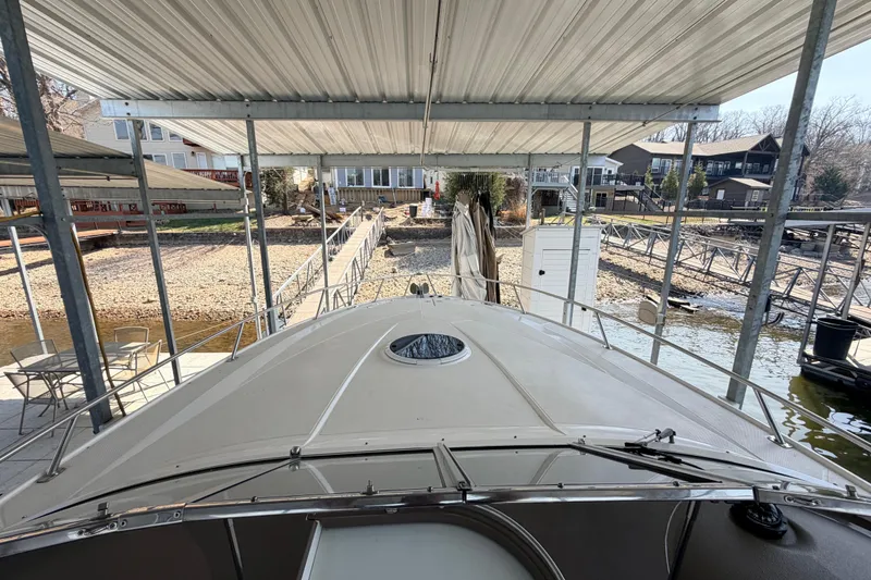 Slide: The Image of 2005 Regal 3350 Sport Cruiser docked under covered marina with waterfront view. - 16