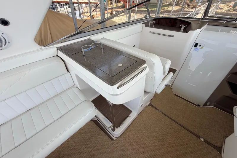 Slide: The Image of 2005 Regal 3350 Sport Cruiser interior with white seating and a compact table. - 18