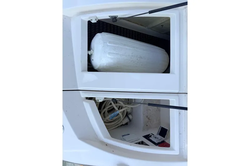 Slide: The Image of Storage compartments on a 2005 Regal 3350 Sport Cruiser, featuring a fender and coiled ropes. - 24