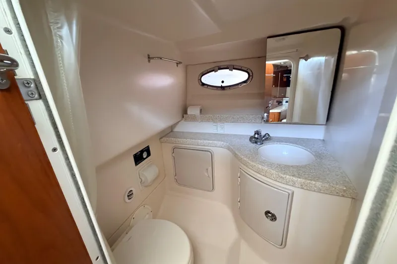 Slide: The Image of 2005 Regal 3350 Sport Cruiser bathroom with sink, toilet, and storage cabinets. - 28