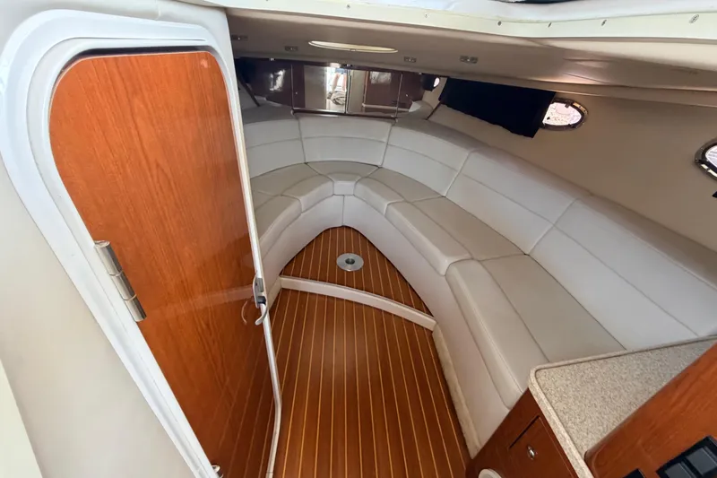 Slide: The Image of Interior of 2005 Regal 3350 Sport Cruiser with white seating and wooden flooring. - 29