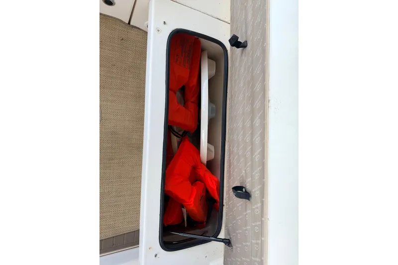 Slide: The Image of Storage compartment with life jackets on a 2005 Regal 3350 Sport Cruiser boat. - 32