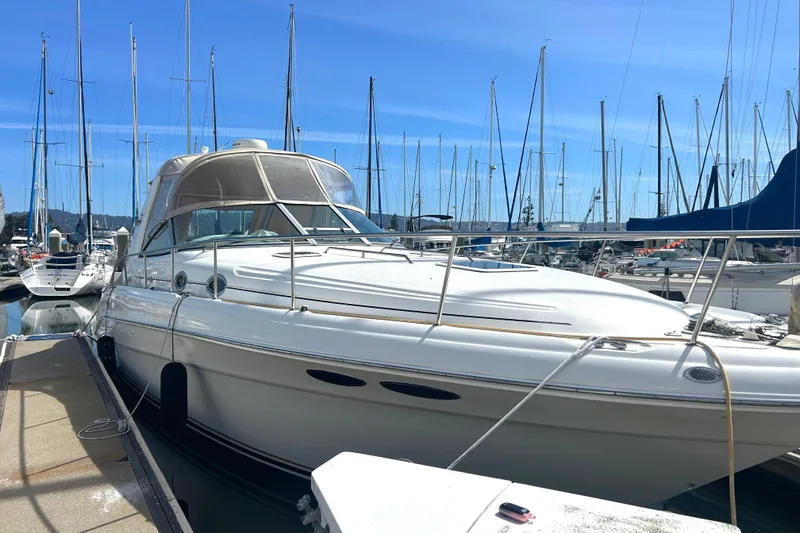 The Image of 2000 Sea Ray 340 Sundancer yacht docked at marina with sailboats in background. - 0