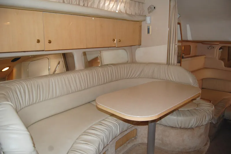 Slide: The Image of Interior of 2000 Sea Ray 340 Sundancer yacht with beige leather seating and wooden cabinetry. - 10