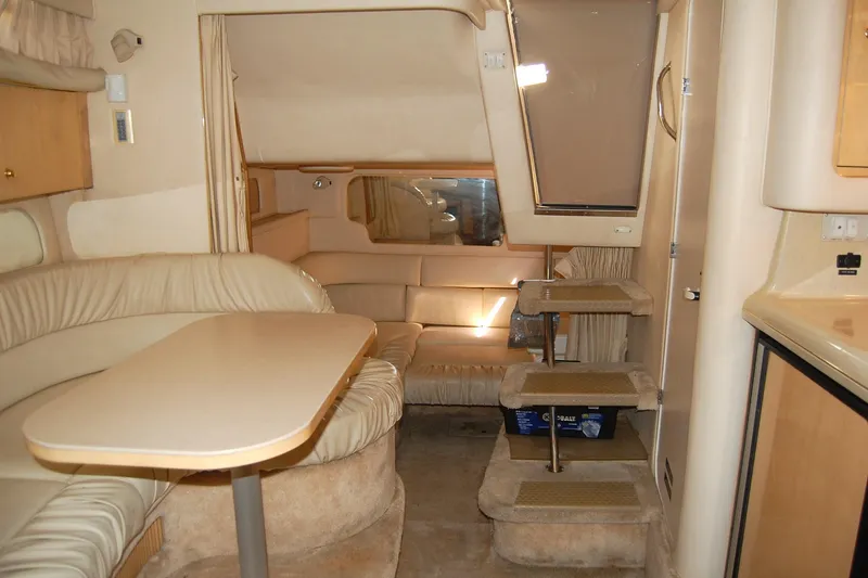 Slide: The Image of Interior of 2000 Sea Ray 340 Sundancer yacht with beige seating and compact dining area. - 11
