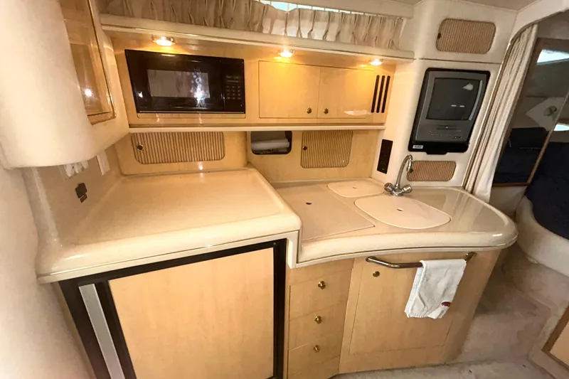 Slide: The Image of 2000 Sea Ray 340 Sundancer galley with microwave, sink, and compact fridge. - 14