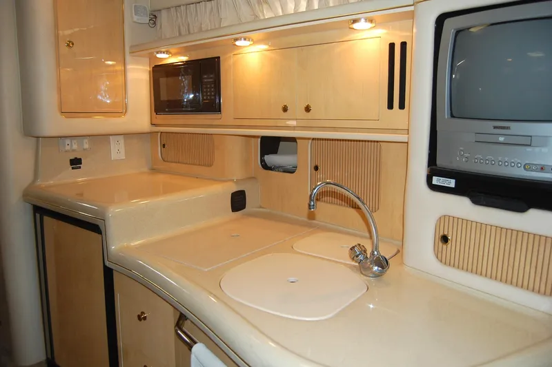 Slide: The Image of 2000 Sea Ray 340 Sundancer kitchen with sink, microwave, and TV. - 16