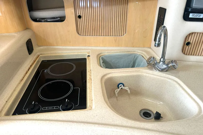 Slide: The Image of Compact kitchen area in a 2000 Sea Ray 340 Sundancer boat with stove and sink. - 19