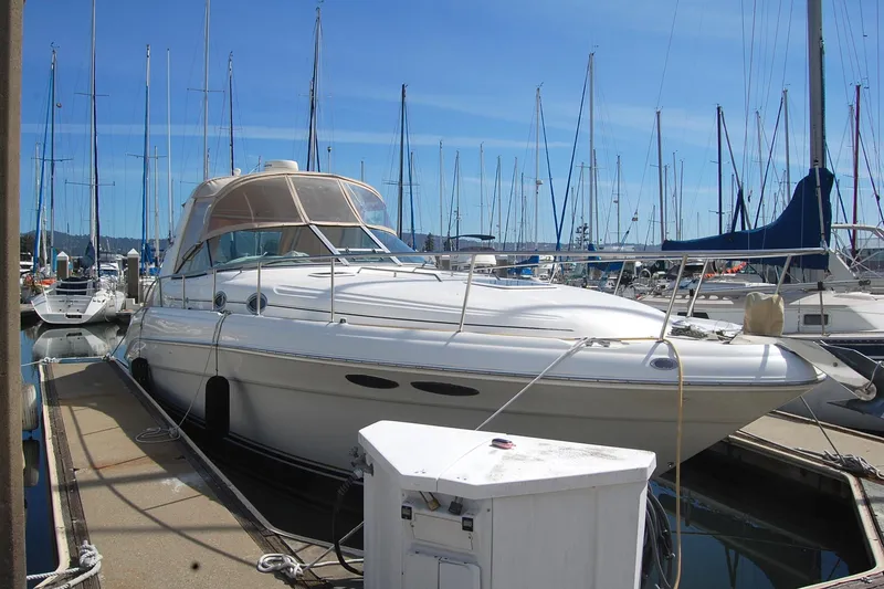 Slide: The Image of 2000 Sea Ray 340 Sundancer docked at marina with sailboats in background. - 2