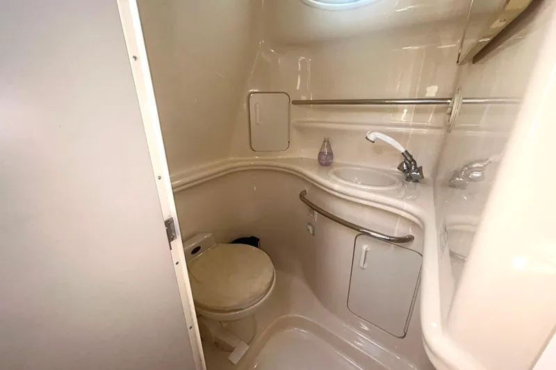 Slide: The Image of Compact bathroom in a 2000 Sea Ray 340 Sundancer yacht, featuring a toilet and sink. - 24