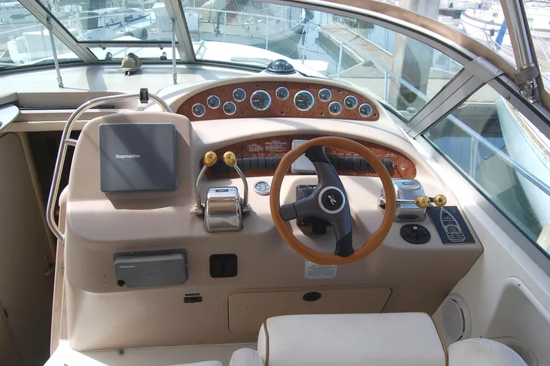 Slide: The Image of Cockpit of 2000 Sea Ray 340 Sundancer with steering wheel and navigation controls. - 26