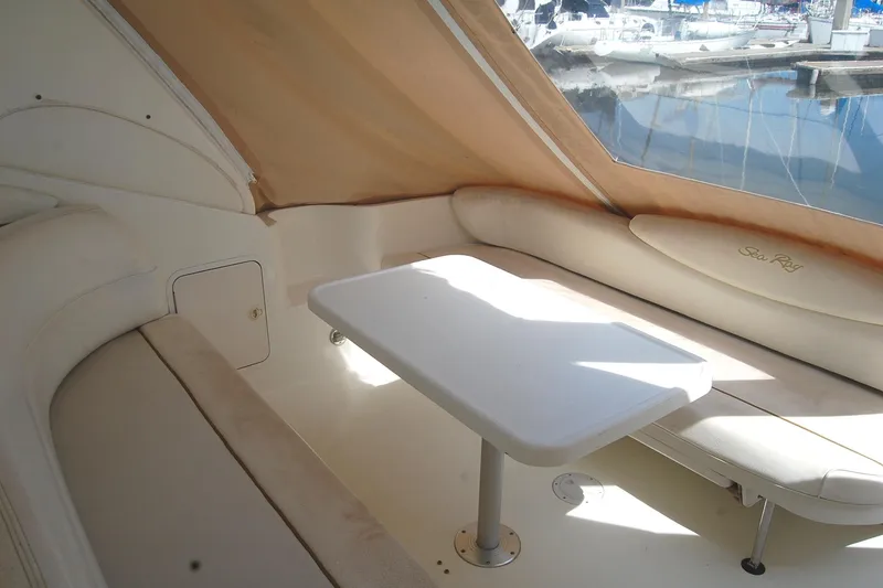 Slide: The Image of Interior seating area of a 2000 Sea Ray 340 Sundancer yacht with table and cushions. - 33