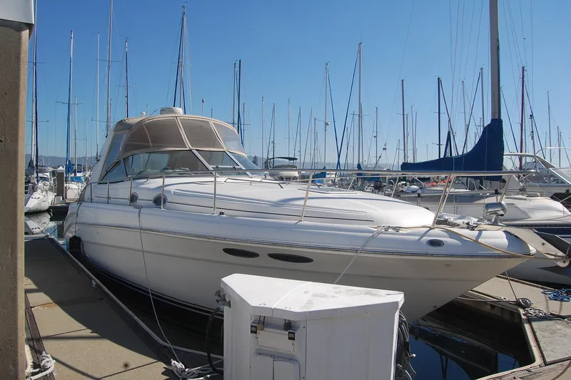 Slide: The Image of 2000 Sea Ray 340 Sundancer docked at marina with sailboats in background. - 4