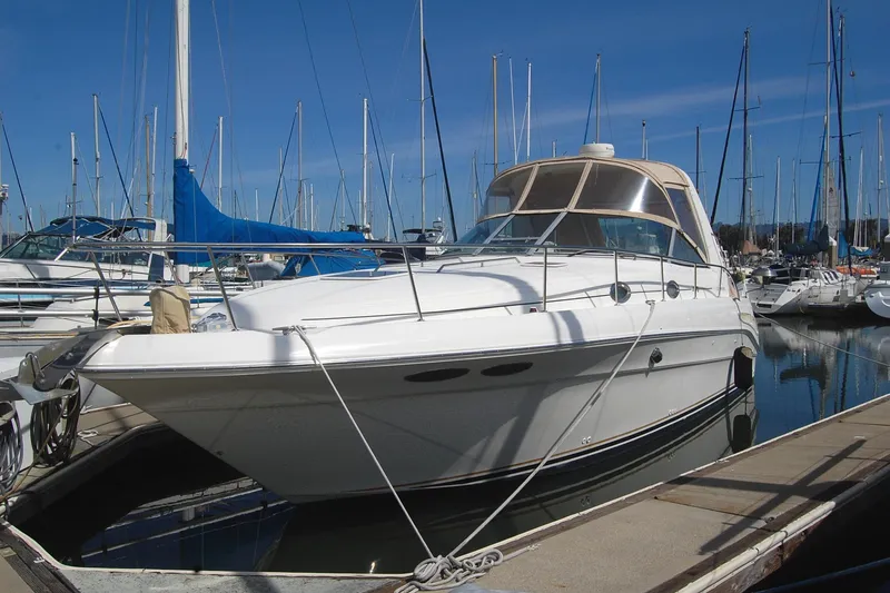 Slide: The Image of 2000 Sea Ray 340 Sundancer yacht docked at marina, surrounded by sailboats under clear blue sky. - 5