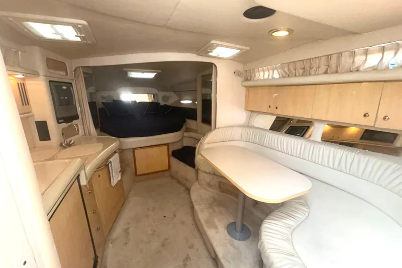 Slide: The Image of Interior of 2000 Sea Ray 340 Sundancer yacht with seating, table, and kitchenette. - 6