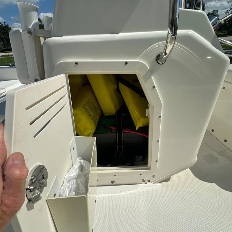 Slide: The Image of Open storage compartment on 2014 Boston Whaler 150 Montauk boat with safety gear. - 12