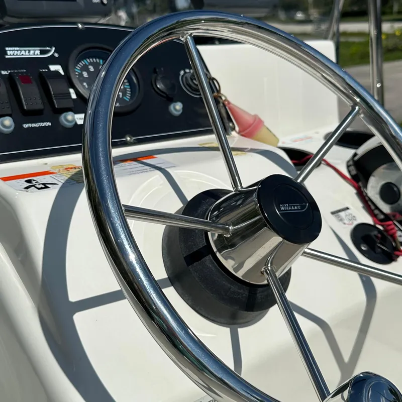 Slide: The Image of Steering wheel of a 2014 Boston Whaler 150 Montauk boat, close-up view. - 14