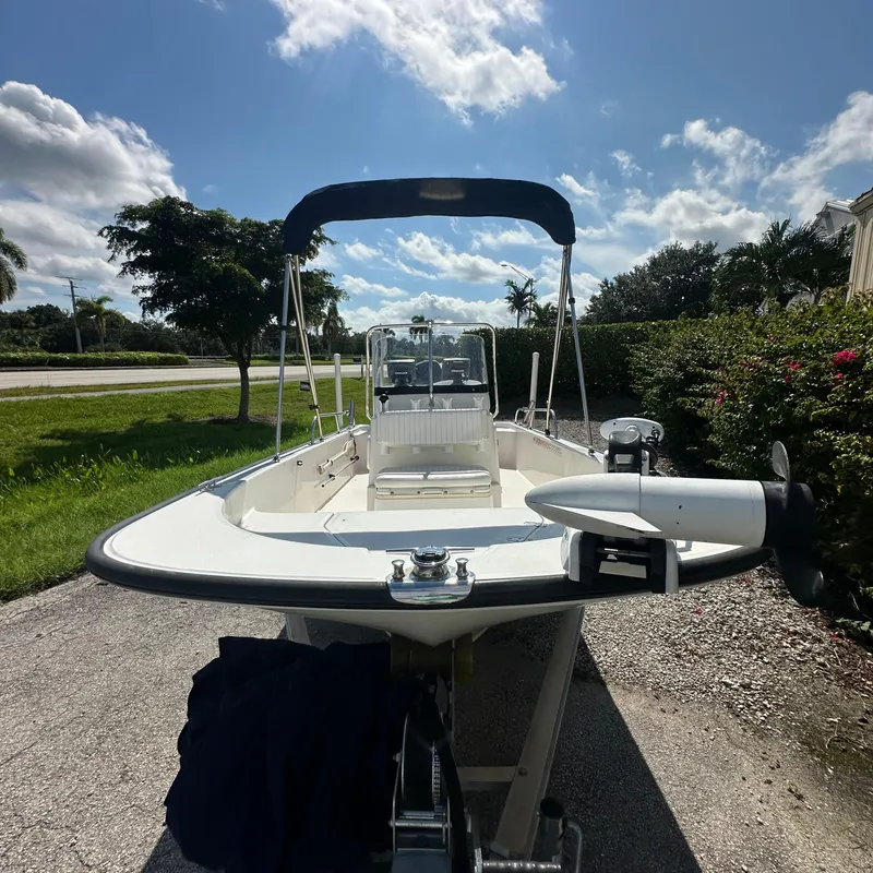 Slide: The Image of 2014 Boston Whaler 150 Montauk boat with canopy, parked on a sunny day. - 18