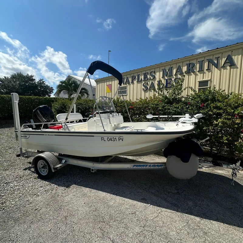 Slide: The Image of 2014 Boston Whaler 150 Montauk boat at Naples Marina Sales under a clear sky. - 19