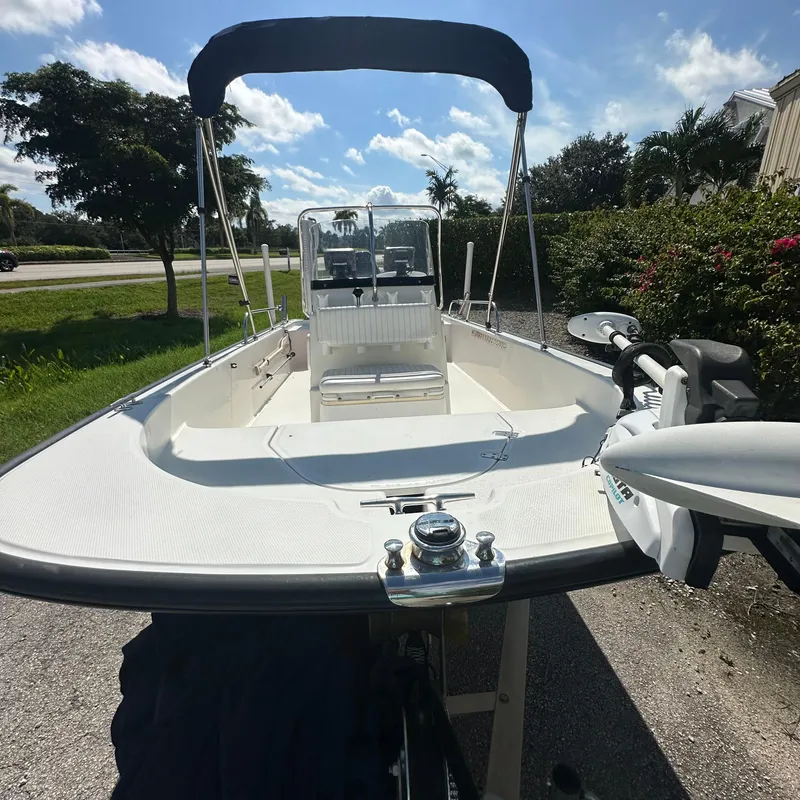 Slide: The Image of 2014 Boston Whaler 150 Montauk boat with canopy, parked outdoors. - 2