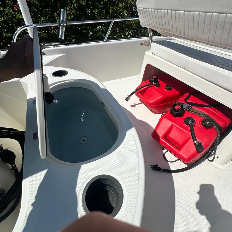 Slide: The Image of 2014 Boston Whaler 150 Montauk interior with storage and red fuel tanks. - 6