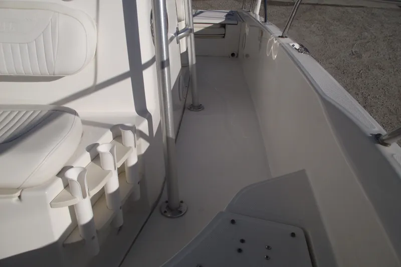 Slide: The Image of Interior view of a 2011 Boston Whaler 230 Dauntless boat, featuring seating and rod holders. - 12