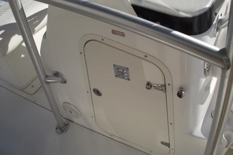 Slide: The Image of 2011 Boston Whaler 230 Dauntless boat interior with storage compartment and railing. - 13