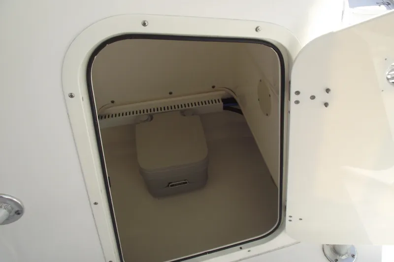 Slide: The Image of Storage compartment on a 2011 Boston Whaler 230 Dauntless boat, featuring a portable toilet. - 14