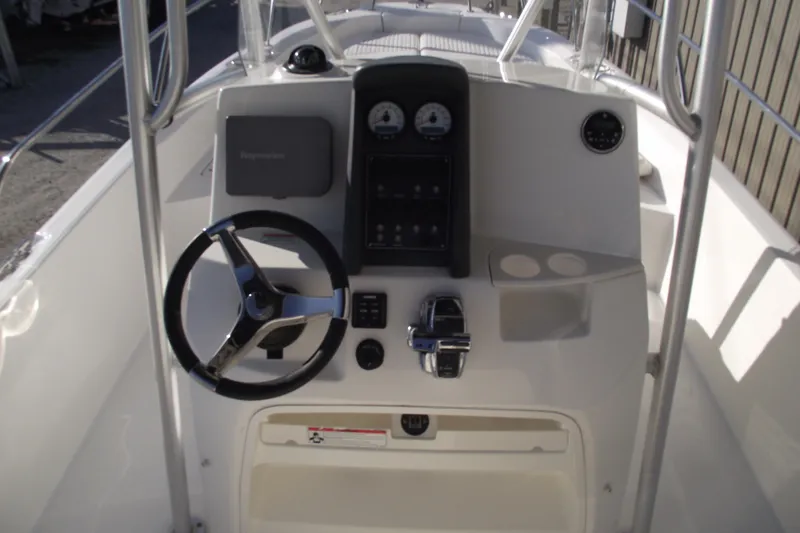 Slide: The Image of 2011 Boston Whaler 230 Dauntless boat console with steering wheel and controls. - 15