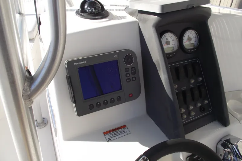 Slide: The Image of 2011 Boston Whaler 230 Dauntless dashboard with Raymarine display and compass. - 18